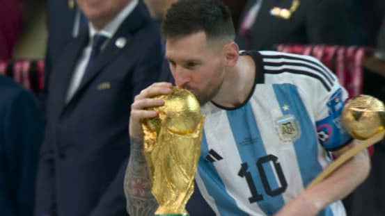Lionel Messi qui embrasse la Coupe du monde après la finale France-Argentine, 18 décembre 2022