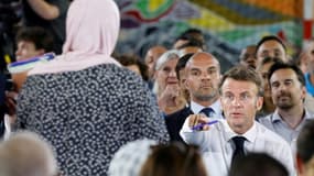 Le président français Emmanuel Macron (d) parle à une mère dans le public présent dans un gymnase du quartier marseillais de La Busserine, le 26 juin 2023