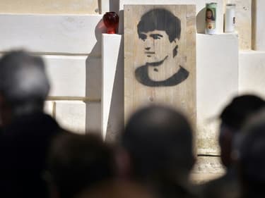 Sur une plaque de bois, à côté de la porte de l'église de Cargèse, en Corse-du-Sud, le visage au pochoir du militant indépendantiste corse Yvan Colonna, tués en prison par un co-détenu, le 25 mars 2022