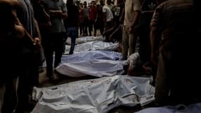 Des Palestiniens se rassemblent autour des corps des victimes tuées par des tirs israéliens visant des civils qui attendaient l'aide humanitaire à Gaza City, Gaza, le 21 août 2025.