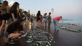 Des personnes réunies autour d'un mémorial sur la Promenade des Anglais lors des commémorations des attentats de Nice le 14 juillet 2017