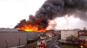 Colonne de fumée au dessus d'entrepôts à la Courneuve, en Seine-Saint-Denis, où le feu s'est déclaré jeudi après-midi dans un parc de 12.000 m2. Environ 150 riverains ont été évacués et près de 200 pompiers mobilisés pour combattre le sinistre. Aucune vic