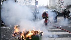 Des pompiers éteignent un feu de poubelle près de la Place d'Italie à Paris, le 16 novembre 2019