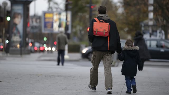 Un père emmène son fils à l'école, lundi 16 novembre, à Paris.