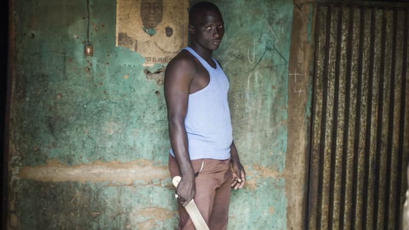 Un Malien pose devant son domicile avec une machette pour se protester contre les attaques des groupes djihadistes à Mopti, au Mali, en janvier 2013.