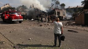Une habitante observe les secours tentant d'éteindre une maison endommagée par une frappe, à Kostyatynivka, dans la région du Donetsk, le 21 juillet 2024. Photo d'illustration
