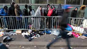 Des réfugiés patientent devant un centre d'accueil, à Paris, en janvier 2017.