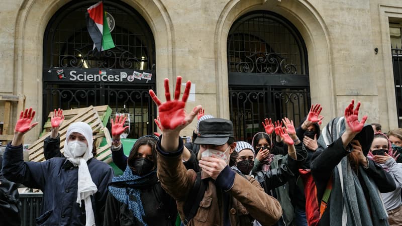 Les manifestants lèvent les mains enduites de peinture rouge pour symboliser le sang alors qu'ils participent à une manifestation devant l'Institut d'études politiques (Sciences Po Paris) occupé par des étudiants, en soutien aux Palestiniens, à Paris le 26 avril 2024.