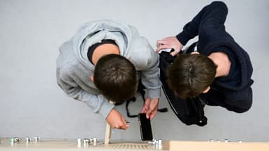 Des élèves déposent leurs téléphones portables dans un casier après l'avoir éteint, au collège Auguste Brizeux à Lorient, le 5 septembre 2024 dans le Morbihan