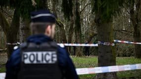 Un policier devant un ruban "police" dans le parc des Templiers, à Longjumeau, le 8 février 2025, après la découverte du corps d'une collégienne de 11 ans disparue la veille.