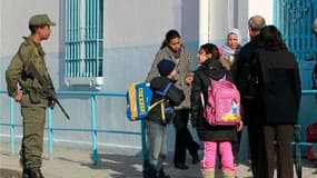 Soldat devant une école primaire du centre de Tunis. Le ministre tunisien de l'Intérieur a évoqué mardi un complot contre la sûreté de l'Etat au sein des forces de l'ordre, après divers actes de violence. L'armée tunisienne a procédé mardi à des tirs de s