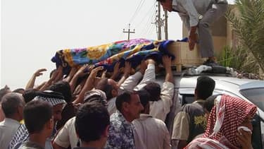 Lors des funérailles d'une victime d'un attentat à Al Souaïra, à 50 km au sud-est de Bagdad. Plusieurs attentats ont fait 65 morts et 200 blessés lundi en Irak, surtout dans la région de Bagdad. /Photo prise le 10 mai 2010/REUTERS/Habib
