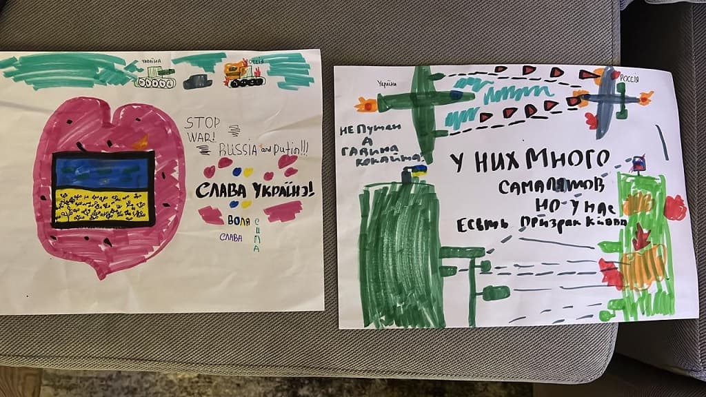 Des dessins réalisés par les fils de Taras Stepanenko (à gauche, vers le cœur avec le drapeau ukrainien "Gloire à l'Ukraine" ; et des tanks et avions ukrainiens qui gagnent face aux Russes).