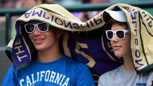 Des spectateurs du tournoi de tennis à Wimbledon tentent de se protéger de la chaleur le 1er juillet 2015 Des spectateurs du tournoi de tennis à Wimbledon tentent de se protéger de la chaleur le 1er juillet 2015