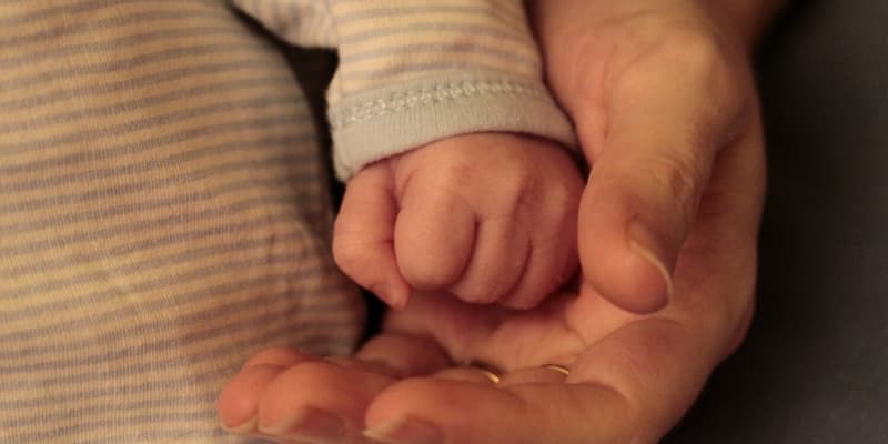 Une main de bébé et celle d'un adulte (Photo d'illustration)