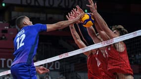 Les Américains David Smith (g) et Torey Defalco contre le smash du Français Stephen Boyer, lors de leur match du 1er tour, le 24 juillet 2021 aux Jeux Olympiques de Tokyo 2020