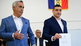 Le leader du parti souverain nationaliste « Alliance pour l'Union des Roumains » AUR George Simion dépose son bulletin de vote à côté de l'ancien candidat Calin Georgescu lors du premier tour de l'élection présidentielle à Bucarest, le 4 mai 2025. 