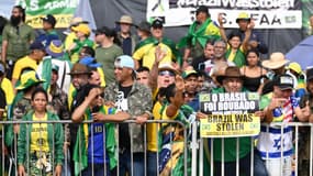 Des partisans de Jair Bolsonaro tiennent des pancartes "Le Brésil a été volé" pour contester la victoire de Lula à la présidentielle, à Brasilia, le 29 décembre 2022