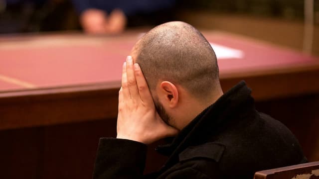 Un des accusés se tient le visage lors de l'introduction du procès de la cellule de Verviers, le 15 avril 2016, au tribunal correctionnel de Bruxelles.