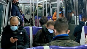 Des personnes portent un masque de protection contre le Covid-19 dans le métro à Paris en novembre 2020