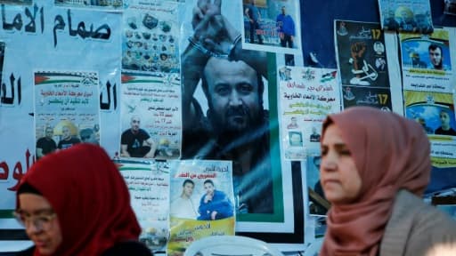 Des palestiniennes passent devant une affiche de Marwan Barghouthi à Ramallah, le 24 avril 2017