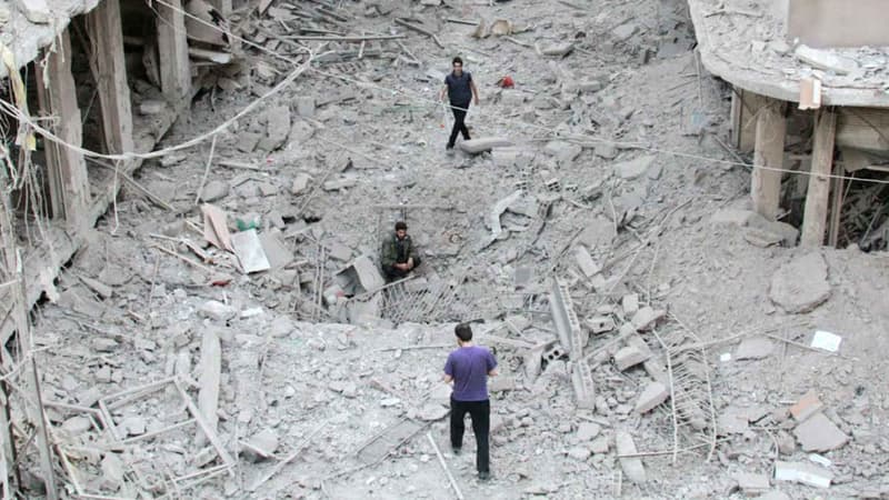 A Daraya, le 28 septembre 2014, des personnes marchent dans les débris, après qu'un hélicoptère des forces gouvernementales syriennes a lâché des bombes. (Photo d'illustration)