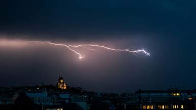 Un éclair dans un ciel d'orage près de la basilique du Sacré Coeur à Montmartre, le 25 juin 2025 à Paris