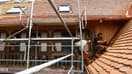 Des ouvriers travaillent à la rénovation d'une maison alsacienne typique à Uttwiller (Bas-Rhin) le 22 mai 2024.