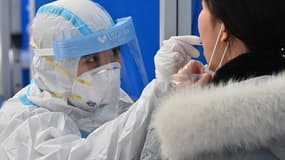 Un personnel soignant administrant un test Covid à Séoul, le 27 novembre 2020