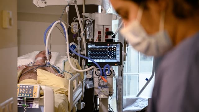 Une soignante s'occupe d'un homme infecté par le coronavirus à l'hôpital Avicenne de Bobigny, près de Paris, le 8 février 2021