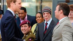 Martyn Compton (coiffé d'un bonnet), ancien compagnon d'armes de William (à gauche) en Afghanistan, où il a été grièvement blessé, lors d'une visite du prince dans un centre de rééducation de l'armée. Le caporal Compton fait partie des invités du mariage