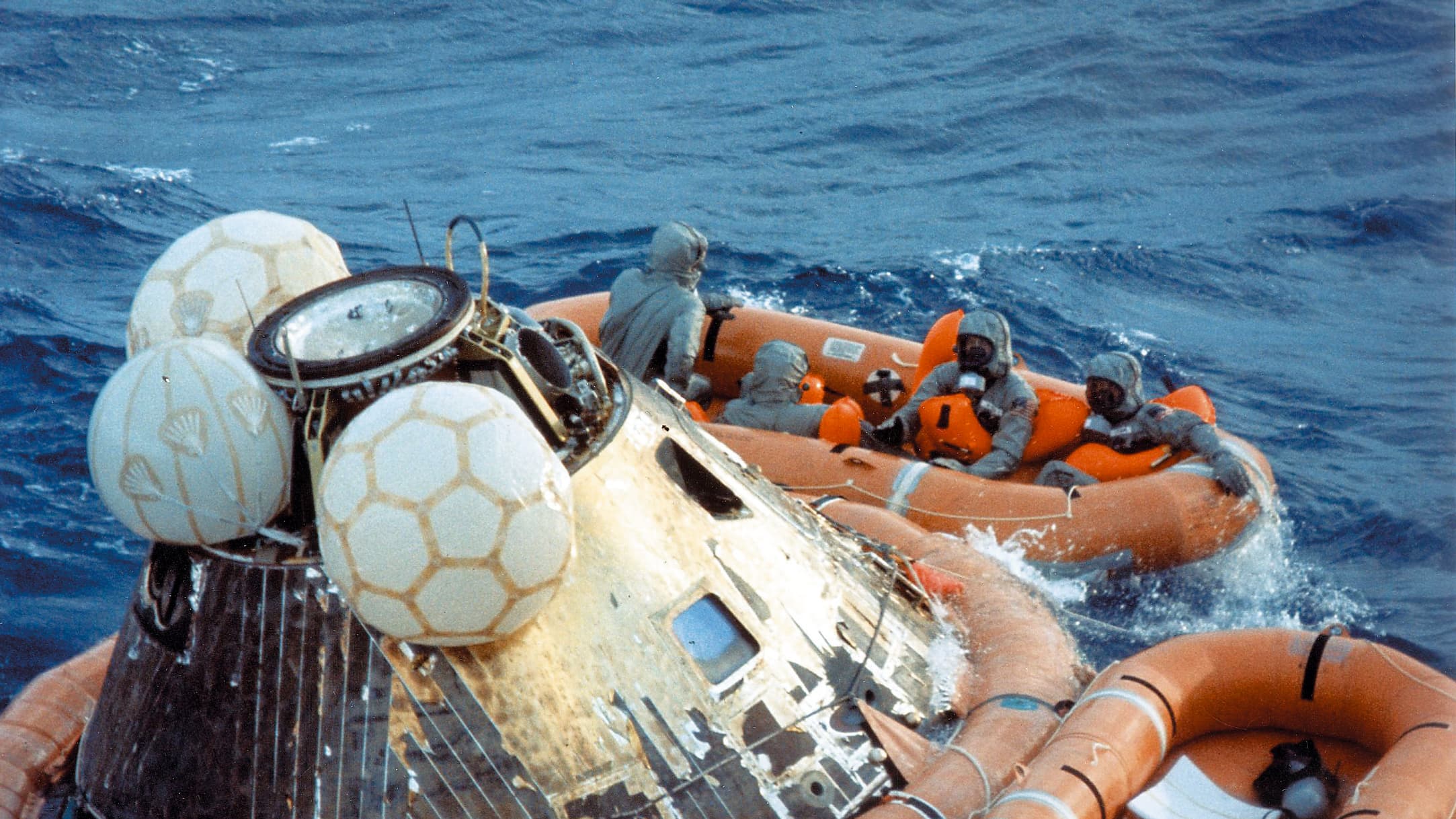 Neil Armstrong, Buzz Aldrin et Michael Collins peu après leur amerrissage dans l'océan Pacifique, accompagnés d'un militaire chargé de les décontaminer. Neil Armstrong, Buzz Aldrin et Michael Collins peu après leur amerrissage dans l'océan Pacifique, accompagnés d'un militaire chargé de les décontaminer.