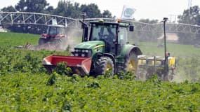 Un tracteur portant le drapeau du syndicat de la FNSEA détruit un champ de cultures OGM en 2014.
