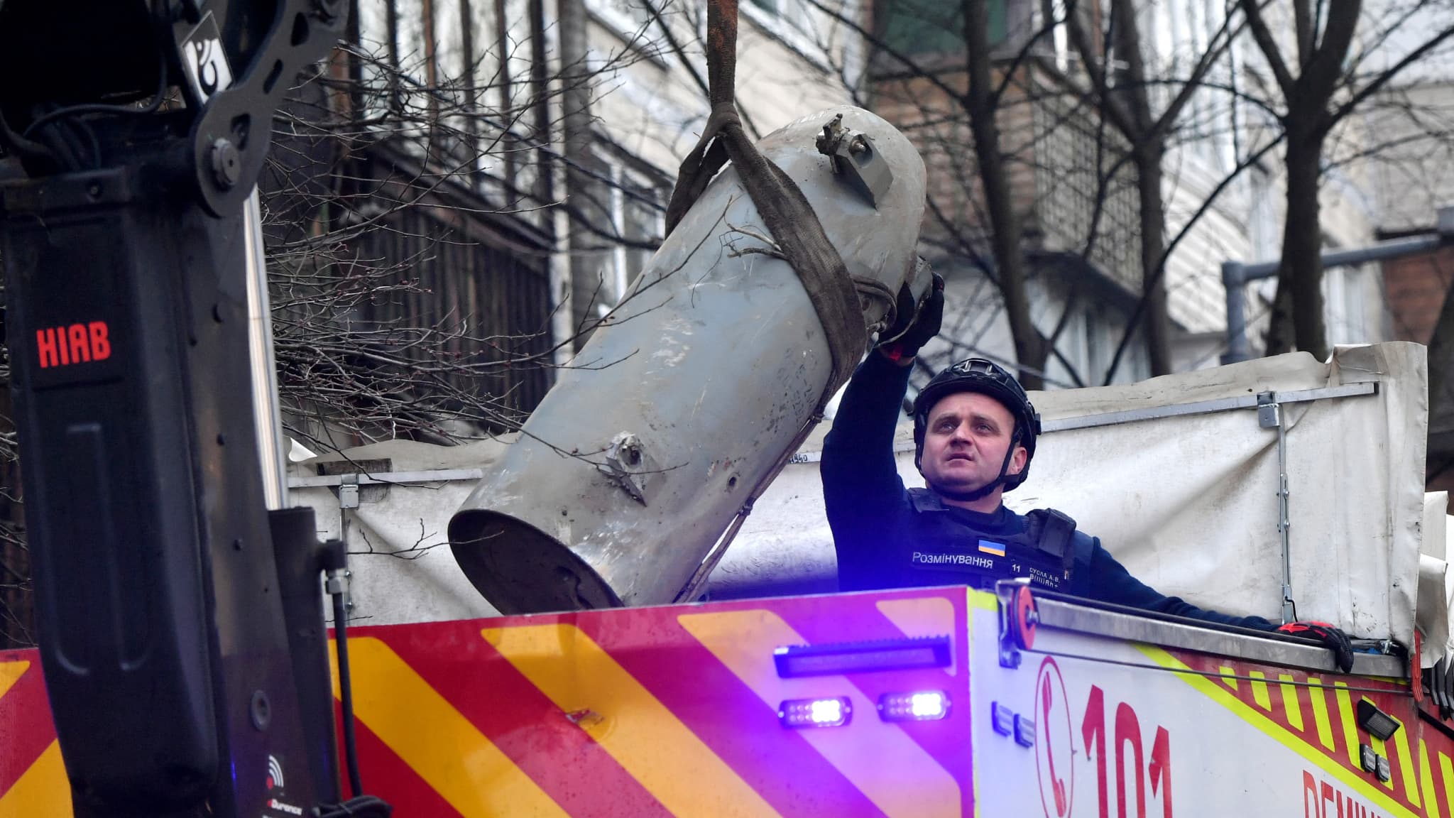 Un démineur ukrainien charge un fragment de missile dans un camion après une frappe russe près d'un immeuble résidentiel de Kiev le 21 mars 2024