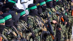 Des combattants du Hamas sécurisent une zone sur une place avant de libérer quatre otages israéliens à une équipe de la Croix-Rouge dans la ville de Gaza, le 25 janvier 2025.