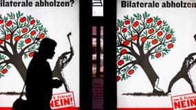 Une personne passe devant une affiche contre "l'immigration de masse", à Zurich.