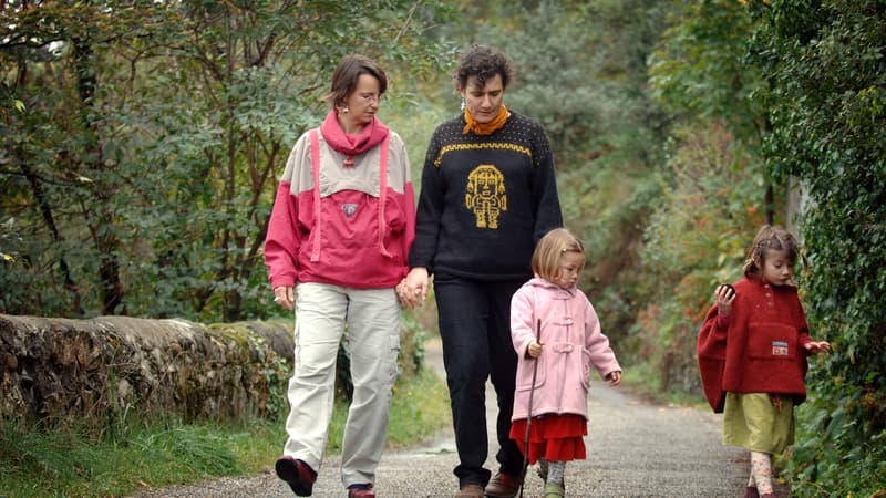 Une famille homoparentale se balade dans un parc - image d'illustration.