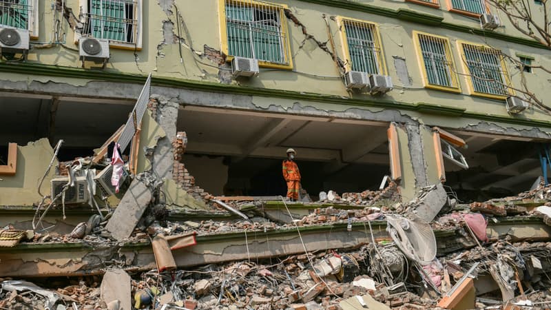 Un secouriste observe l'immeuble Sky Villa Condominium largement détruit par un séisme à Mandalay, en Birmanie, le 29 mars 2025