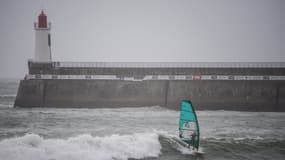 Un véliplanchiste surfe sur une vague au large de la plage des Sables-d'Olonne le 30 janvier 2021, alors que la tempête Justine atteint la côte ouest de la France.