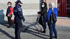 Une policière discute avec une habitante de Canonica d'Adda, en Lombardie (nord de l'Italie), qui fait la queue pour la supérette, le 7 avril 2020