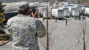 Un soldat américain photographie des camions Sud Coréens forcés de revenir du site de Kaesong le mercredi 3, 2013.