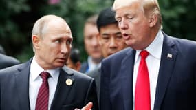 Le président américain Donald Trump (à droite) et le président russe Vladimir Poutine discutent alors qu'ils se dirigent vers la « photo de famille » lors du sommet des dirigeants de la Coopération économique Asie-Pacifique (APEC) dans la ville centrale vietnamienne de Danang, le 11 novembre 2017. 