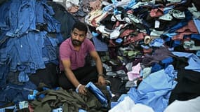 Un employé trie des chemises et des jeans dans un atelier en Inde le 25 août 2025.