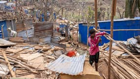 Un homme travaille à la reconstruction d'une maison détruite dans la ville de Vahibe, à la périphérie de Mamoudzou, à  Mayotte, le 24 décembre 2024.
