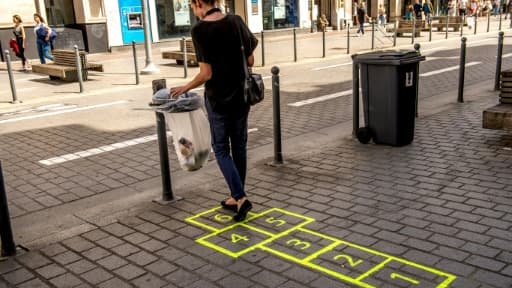 Un pochoir de marelle sur le trottoir guide la personne à une poubelle, à Lille, le 31 juillet 2018