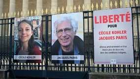 Les portraits de Cécile Kohler et de Jacques Paris, emprisonnés en Iran, accrochés aux grilles de l'Assemblée nationale à Paris, le 25 mars 2025