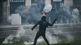 Un manifestant lance une bouteille sur les forces de police lors de heurts à Nantes, le 1er mai 2023