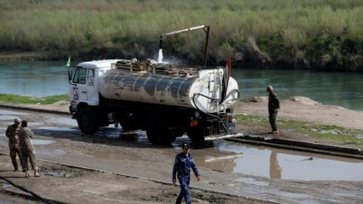 Des soldats irakiens surveillent le remplissage en eau d'un camion-citerne, le 1er avril 2017 à Hamman al-Alil