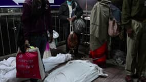 Dix cadavres enveloppés dans des draps blancs étaient visibles sur un quai de la gare plusieurs heures après la bousculade.