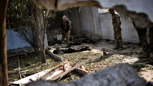 Un membre des forces progouvernemntales irakiennes examine un corps à Mossoul, le 5 mars 2017